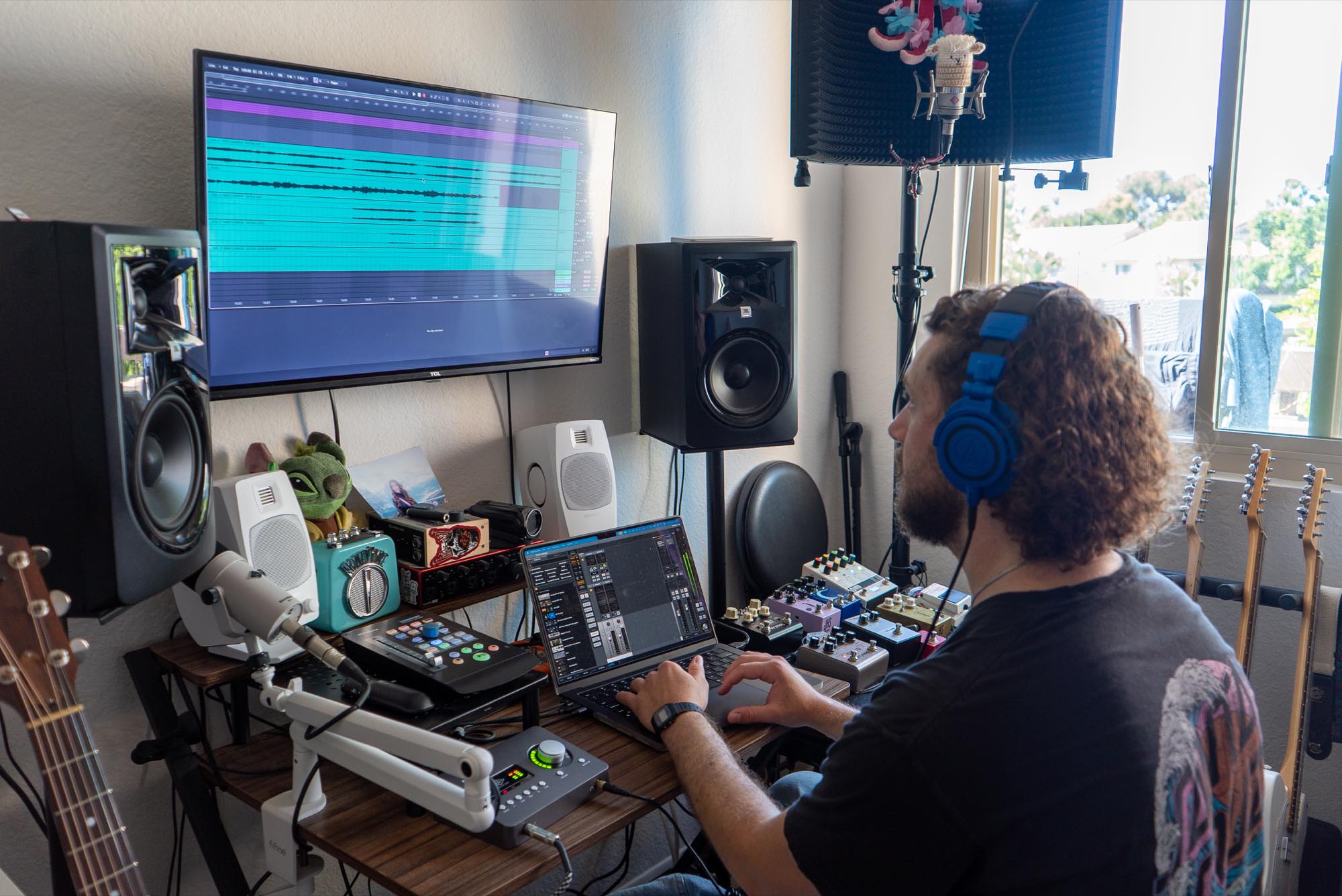 Jordan in headphones at the desk, with a mix session on the screen
