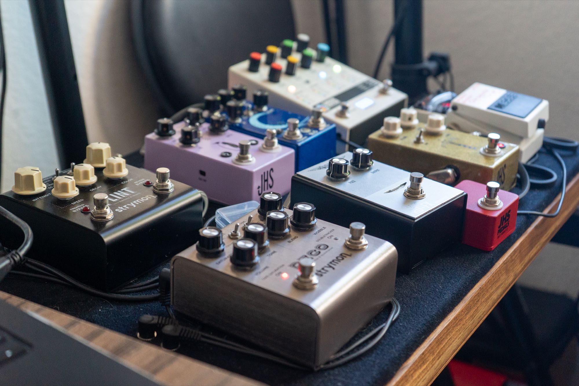 A close-up of guitar pedals arranged on the studio pedalboard